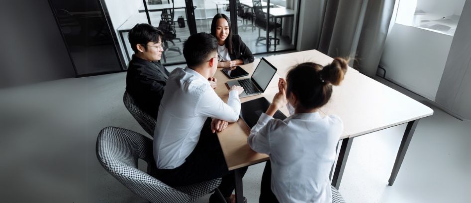 A group of young professionals discussing on selecting the top recruitment agencies in Vietnam.
