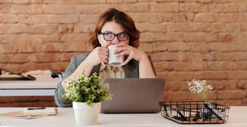 A female professional drinking from her mug while scouting the top recruitment agencies in Vietnam