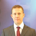 Man in a suit and tie with a blue background.