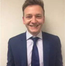 Smiling person in a blue suit and striped shirt