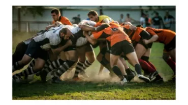Rugby players in a scrum during a match in a grassy field.