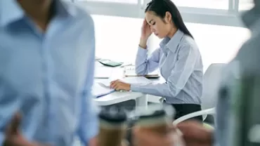 Woman at desk concentrates on paperwork in office