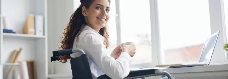 Woman in wheelchair smiling with a cup