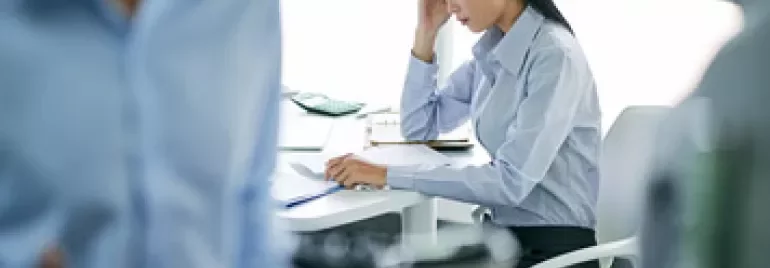 Woman at desk concentrates on paperwork in office