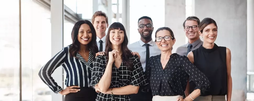 A diverse group of professionals smiling in an office setting.