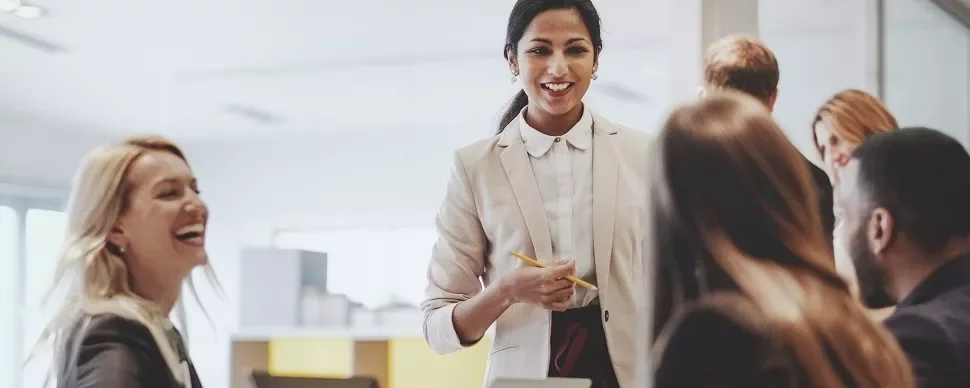 Smiling businesswoman leading a meeting with colleagues in an office.