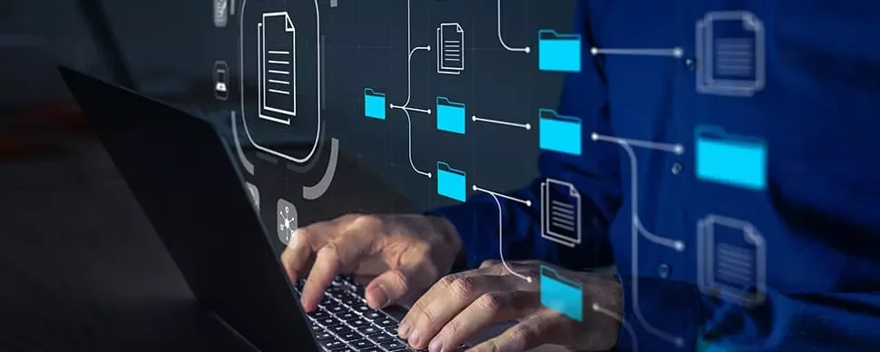 Person working on laptop with digital folder and document icons.
