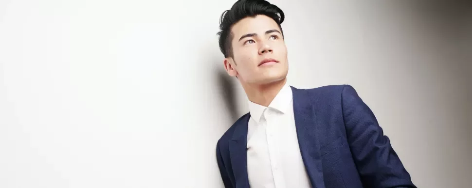 Man in a blue suit and white shirt looking off into distance.