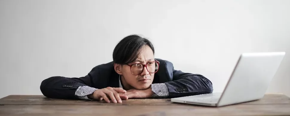 Person in glasses resting head on hands